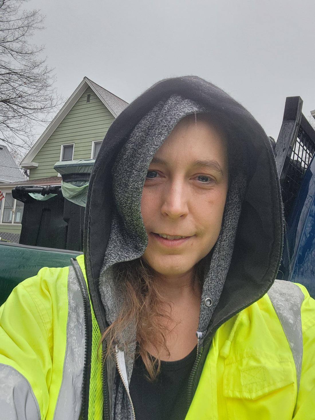 person in reflective rain gear smiles at camera